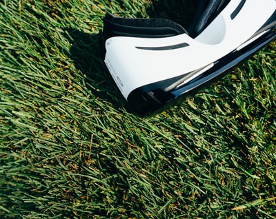 绿色草地上的黑白VR盒式耳机